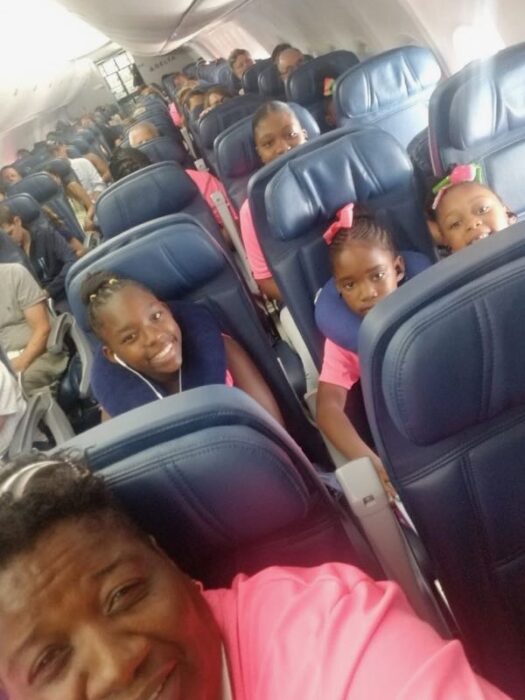 Miss Pat in a selfie with some of the dancers on the plane. 